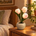 pink LED tulip lamp in a ceramic pot glowing on a bedside table