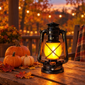 Vintage rechargeable lantern glowing on an autumn porch table
