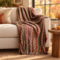 Boho chevron woven throw with tassels draped on a cream sofa