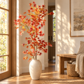 Artificial red Japanese maple branch in a cream floor vase
