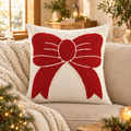 Tufted red bow Christmas pillow on a linen sofa