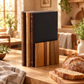 Three book-shaped acacia cutting boards in their stand beside fresh bread