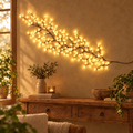 Willow vine light glowing on a warm plaster wall above a rustic console