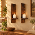 Pair of wooden wall candle sconces holding lit pillar candles