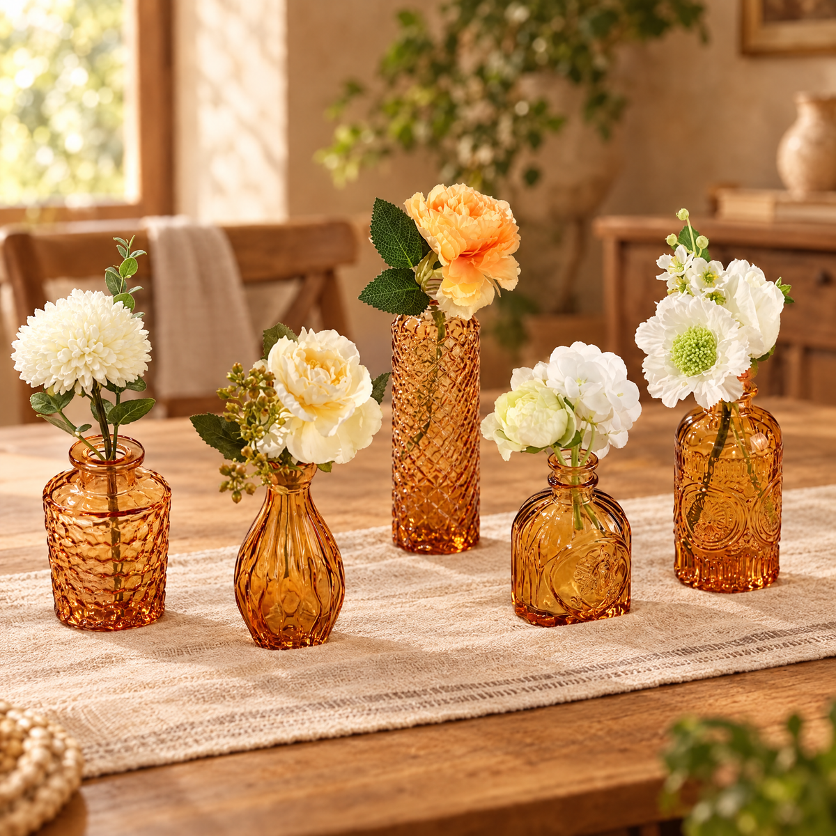 Six amber vintage glass bud vases with fresh flowers on a table runner